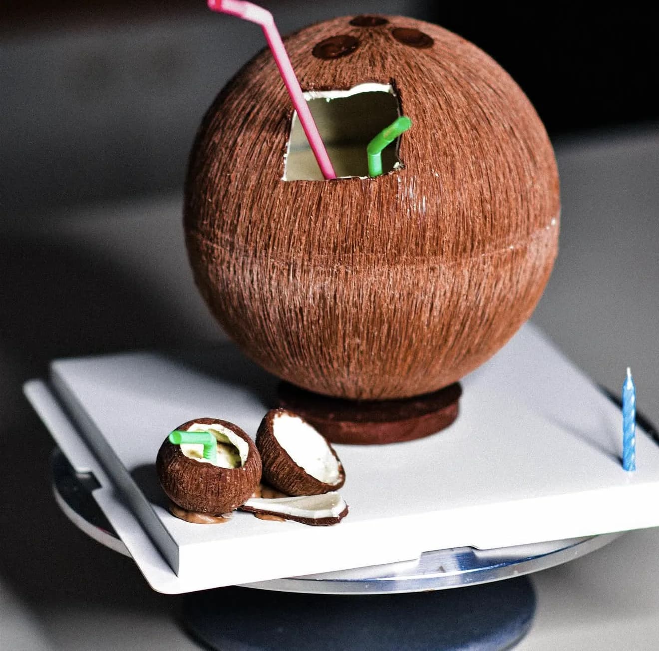 Novelty coconut-shaped sphere cake with fiber texture and straws plus tiny cracked coconut cake pops