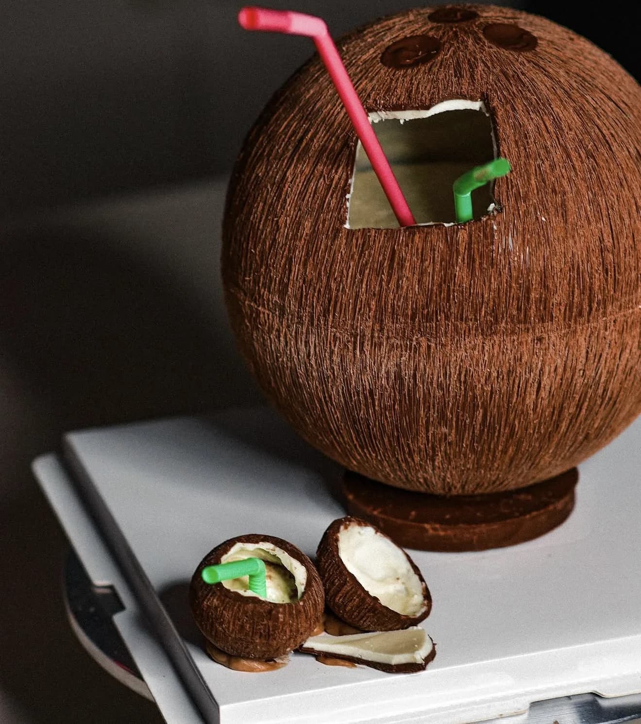 Alternate view of hyperrealistic coconut sphere cake with pink and green straws