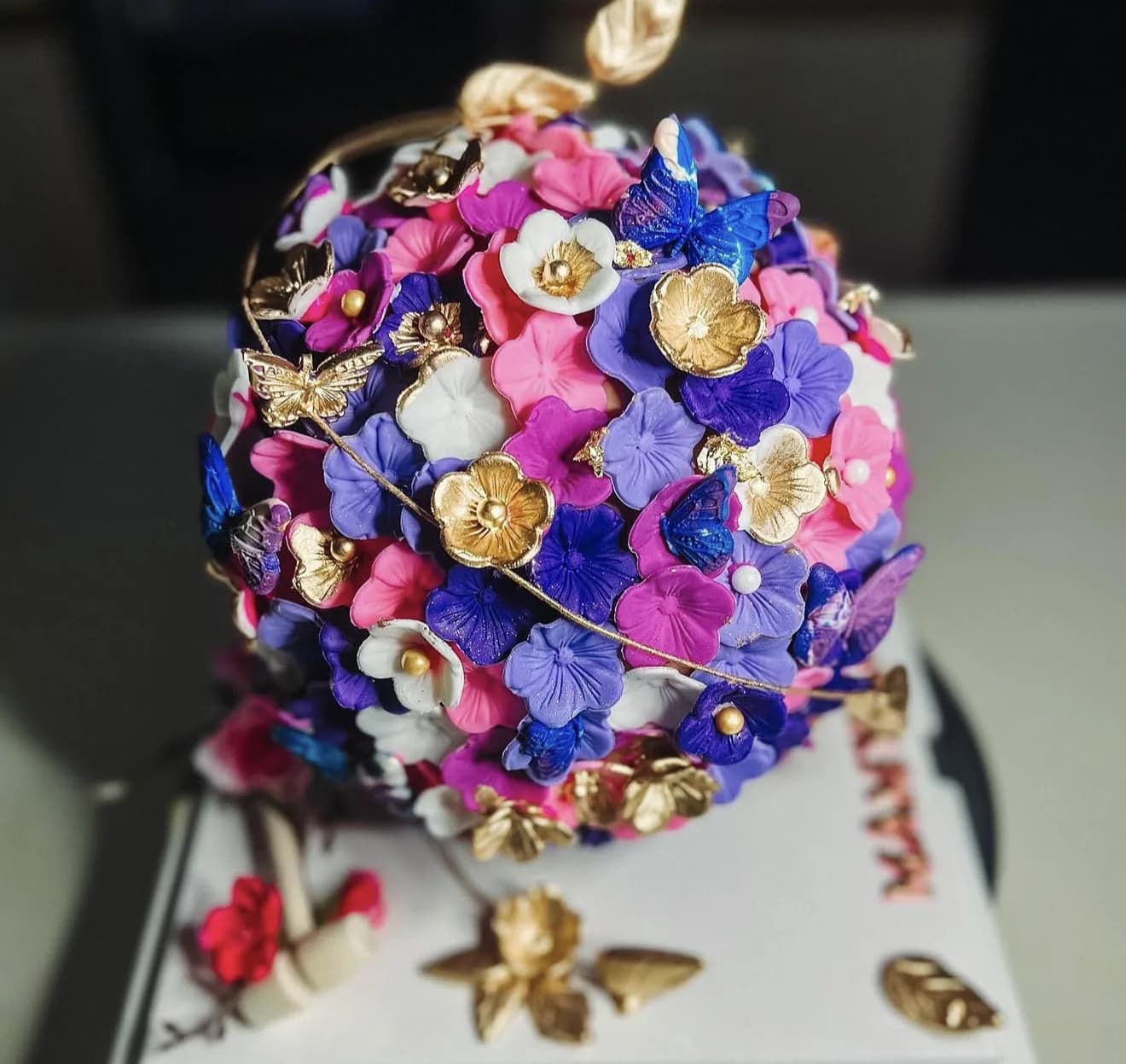 Alternate view of pink purple hydrangea sphere cake with gold butterflies and bees on base