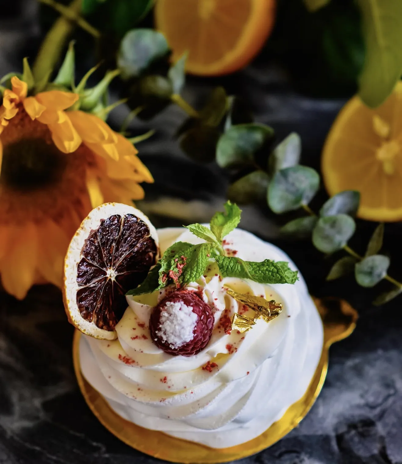 Overhead pavlova dish with sunflower lemon eucalyptus and dried citrus styling