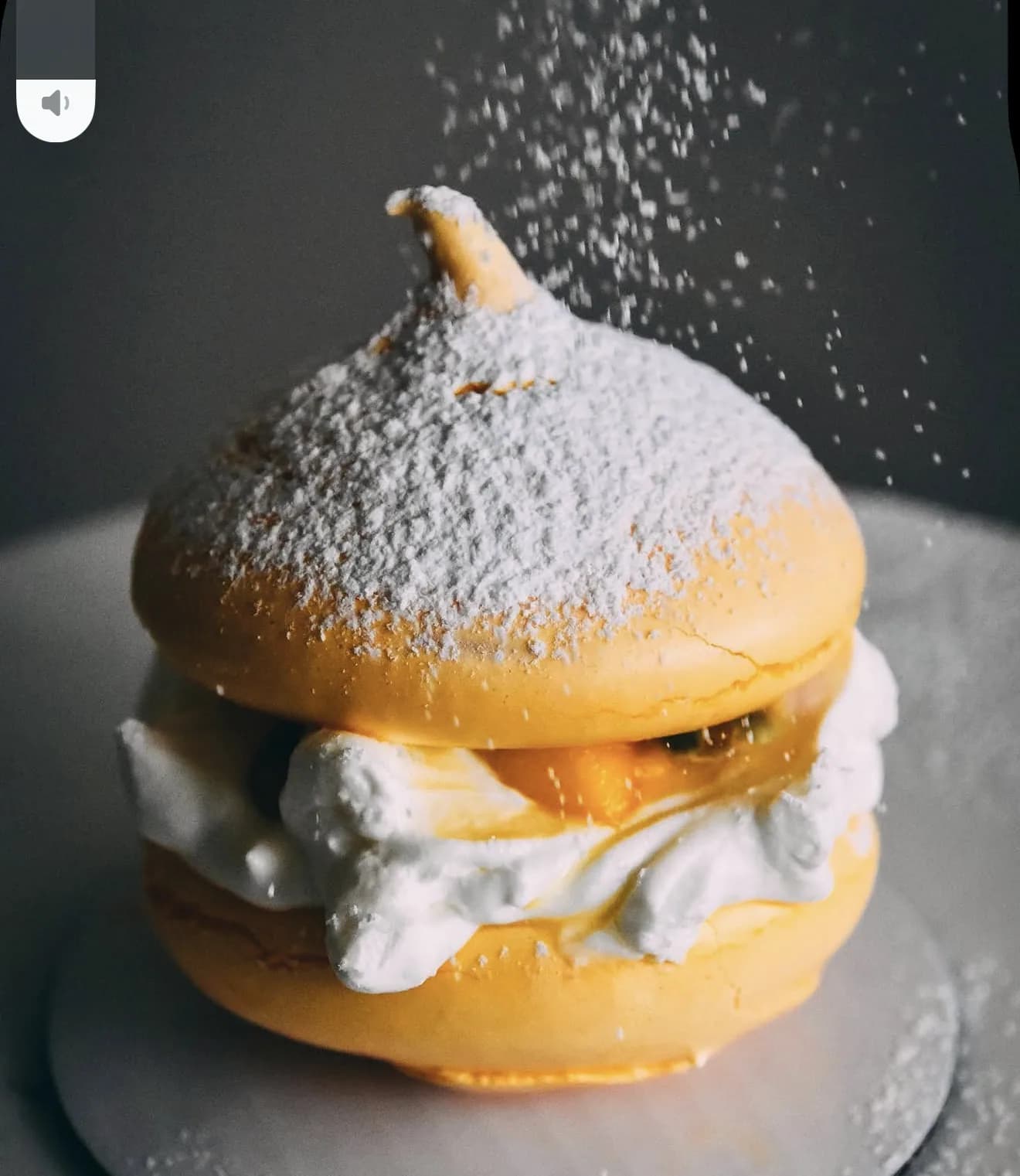 Alternate yellow pavlova with descending powdered sugar and peaked meringue detail