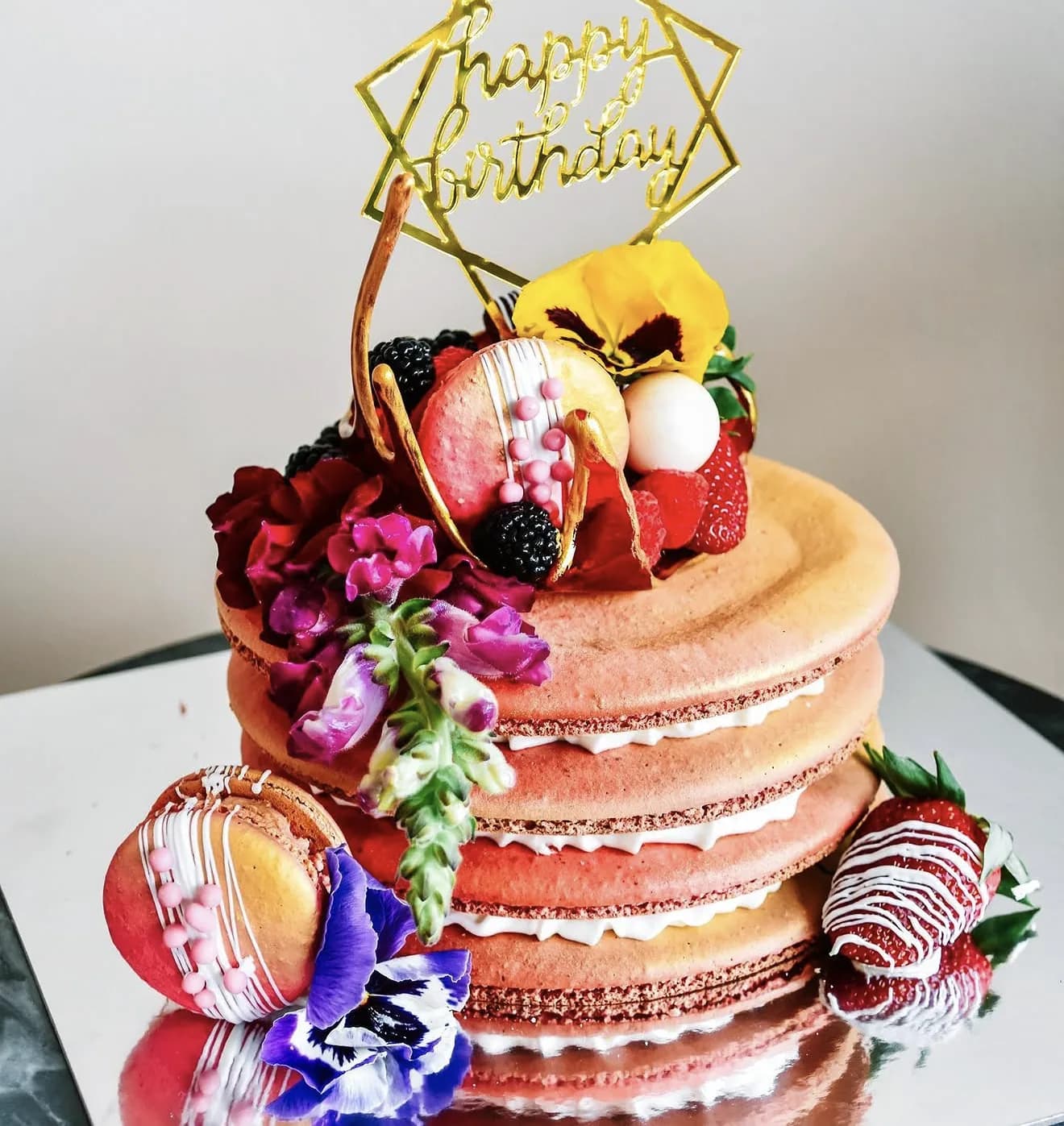 Peach ombre mega macaron stack with chocolate dipped strawberries fresh berries pansies blooms