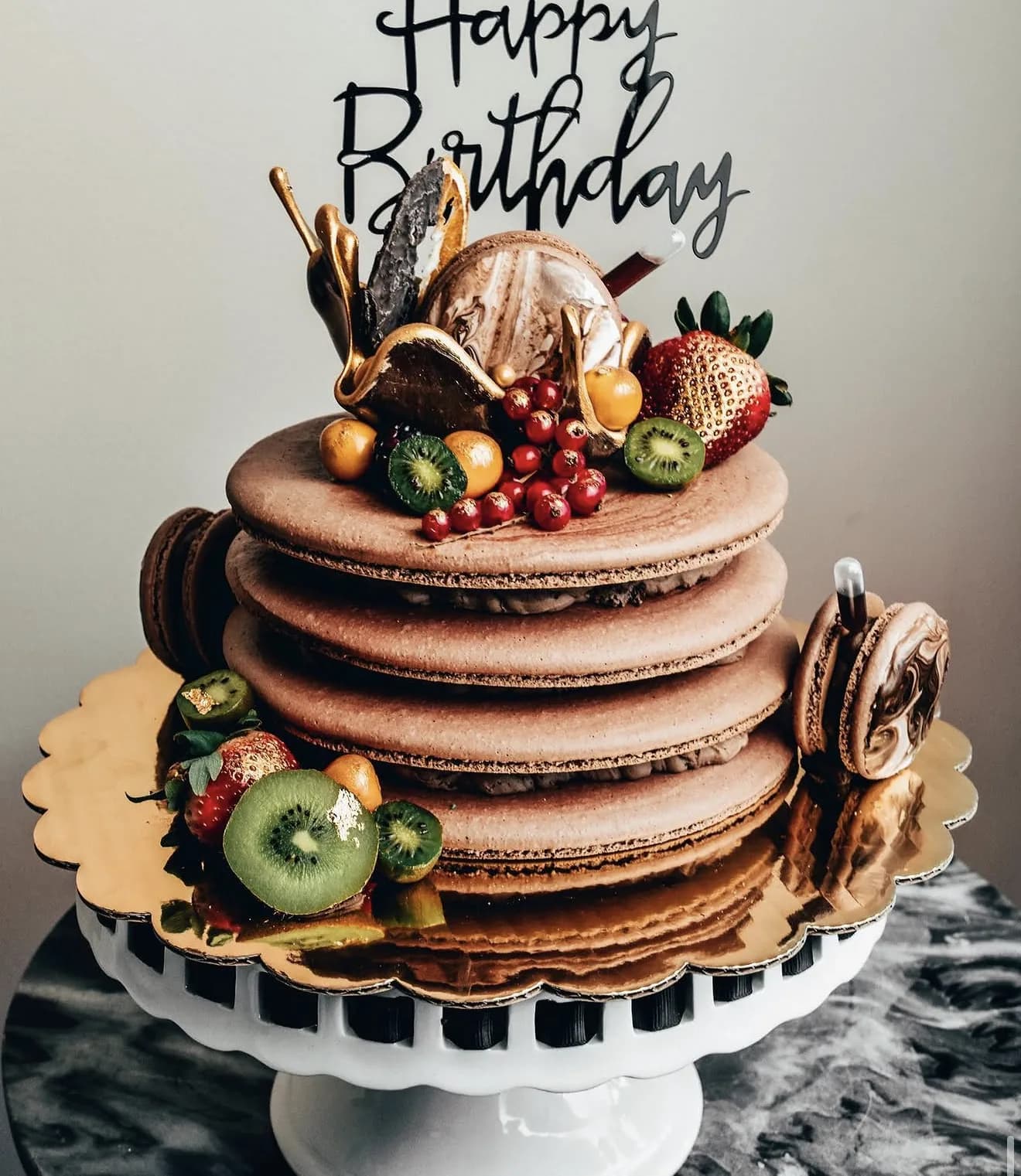 Stacked mocha mega macaron tower with strawberry kiwi red currants and Happy Birthday script