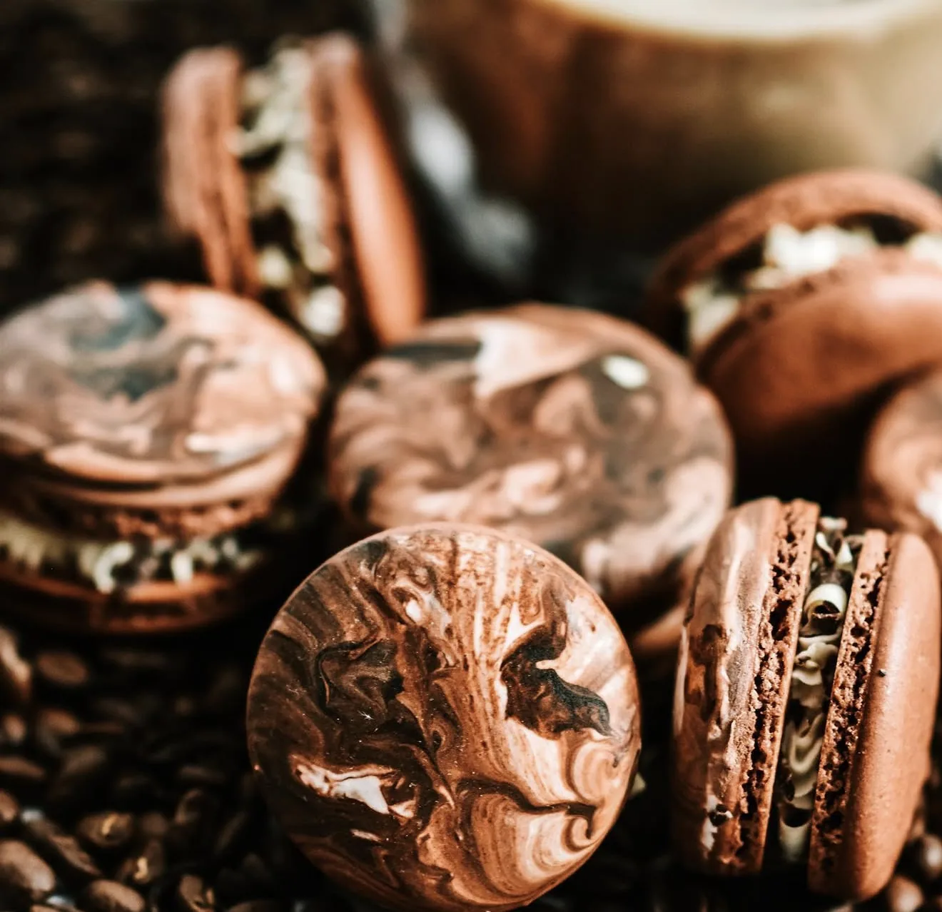 Close-up of mocha marbled macarons on bed of coffee beans with warm tones