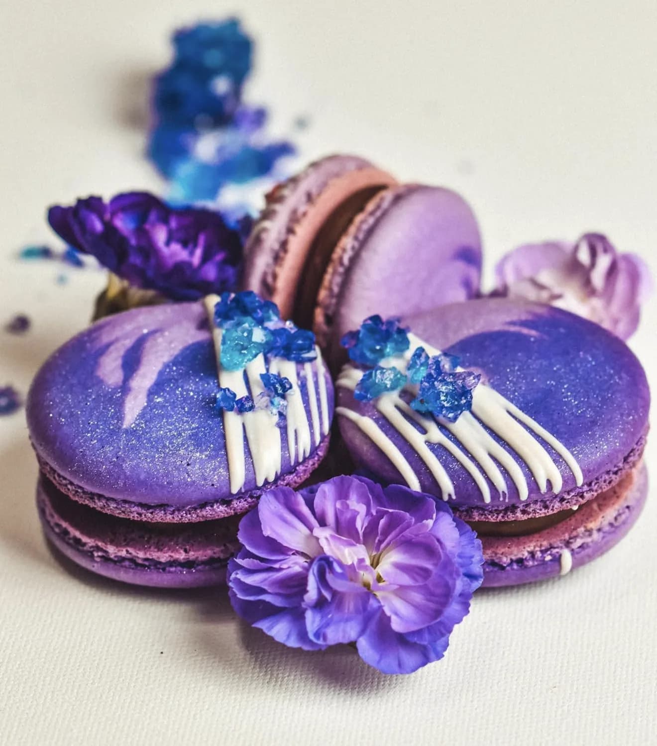 Detail purple macarons with white chocolate stripes and blue sugar amethyst crystal clusters