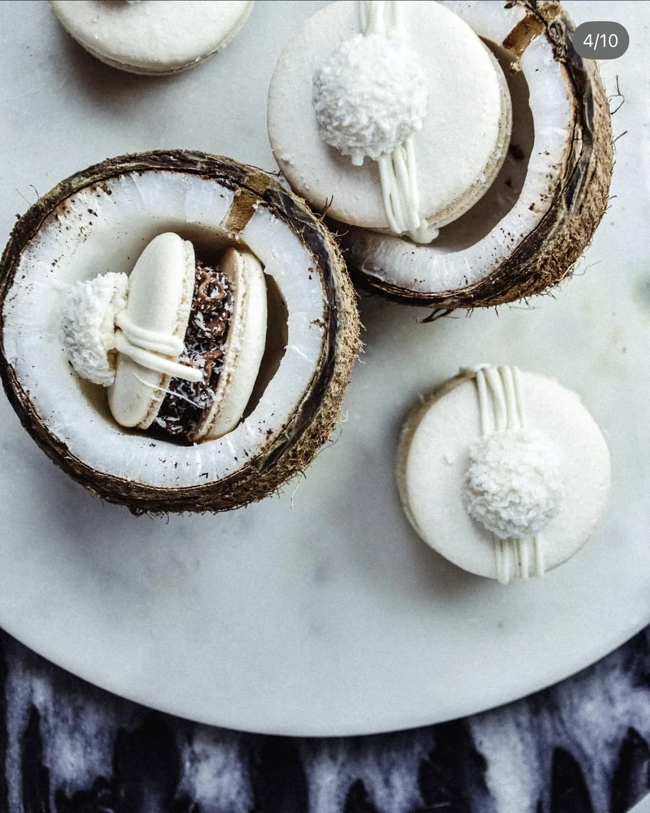 Apricot macarons with white drizzle dried apricot slices and gold pearls on dark surface