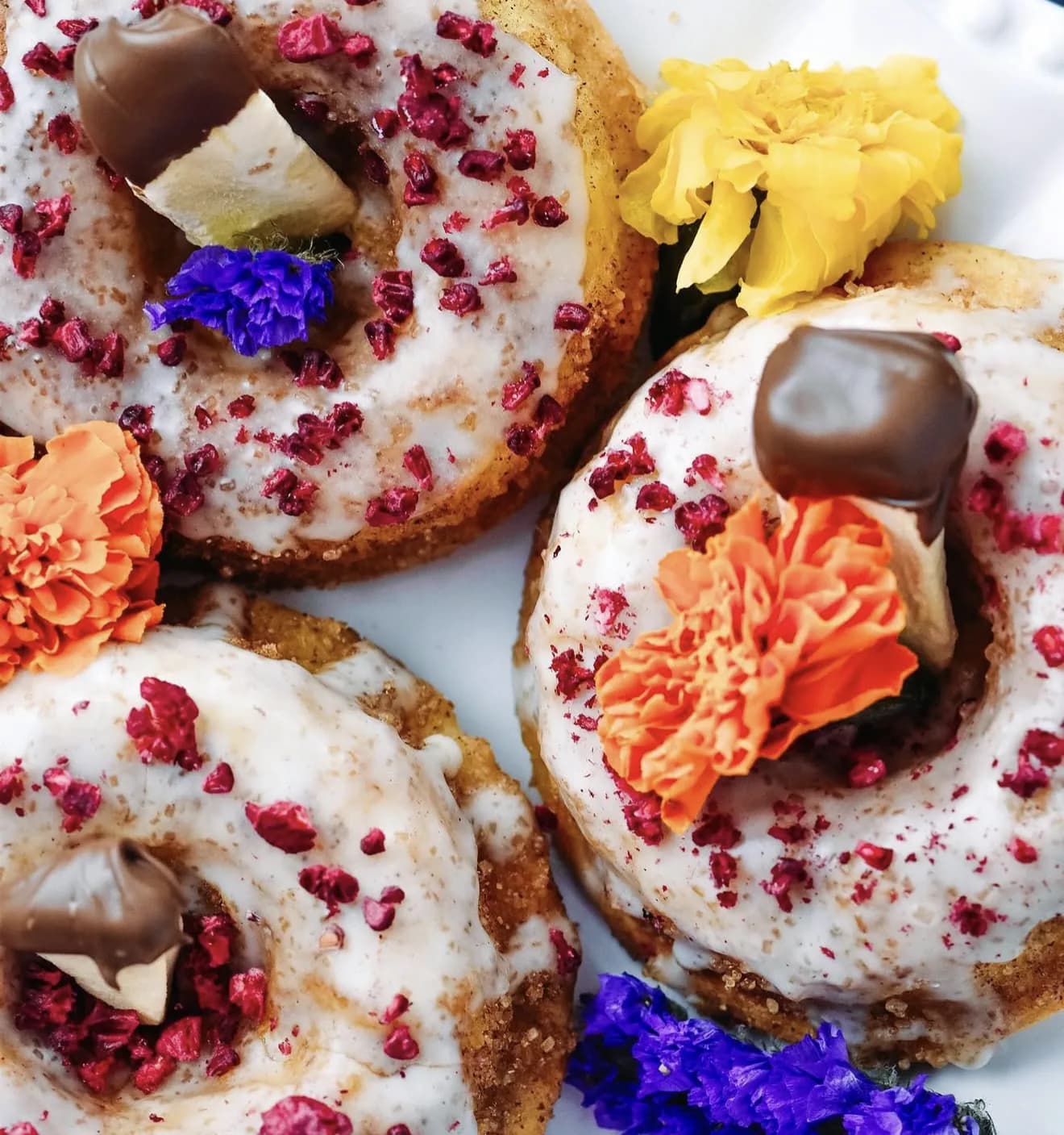 Raspberry crumble lemon donuts with chocolate caramels marigolds and violet statice blooms
