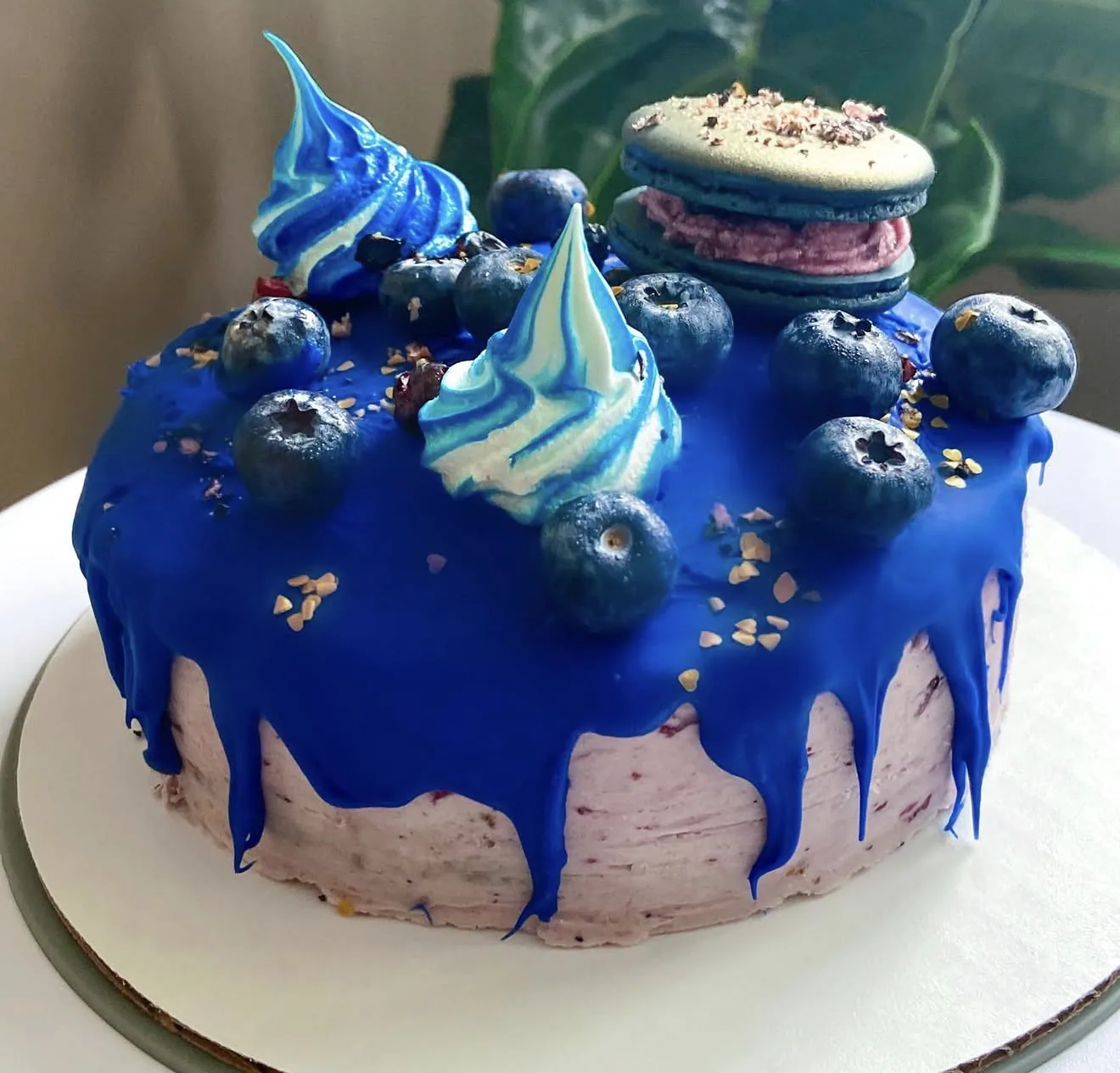 Macarons stacked with waffle cones dipped in chocolate and nuts like upside down ice cream cones